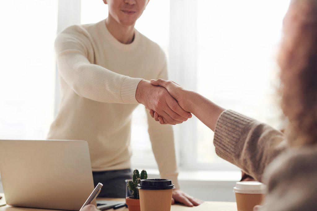 Two business professionals shaking hands after securing a business loan